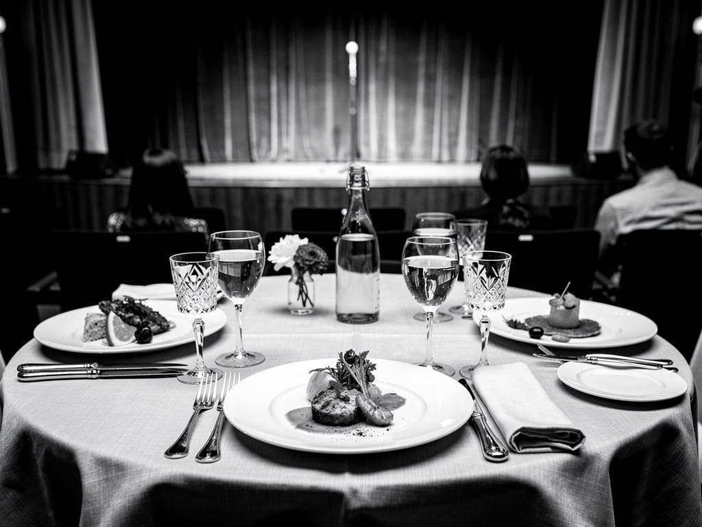 Table de dîner dressée face à une scène de cabaret